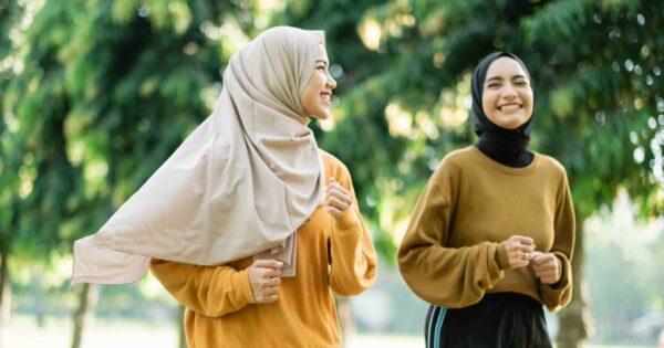 two teenage girls in veil do outdoor sports while jogging together